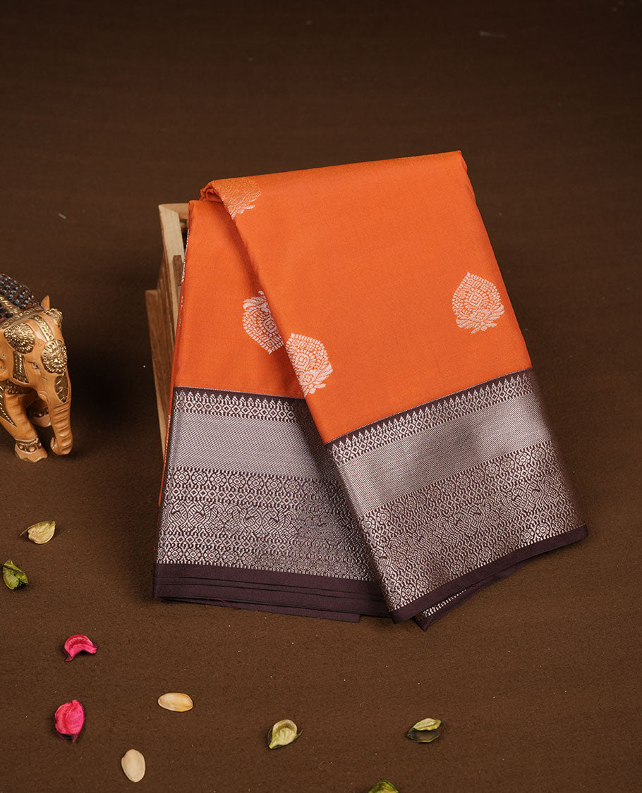 Rust orange colour semi silk saree featuring gold zari floral motifs on body highlighting contrast dark chocolate rose gold zari peacock border , paired with matching blouse