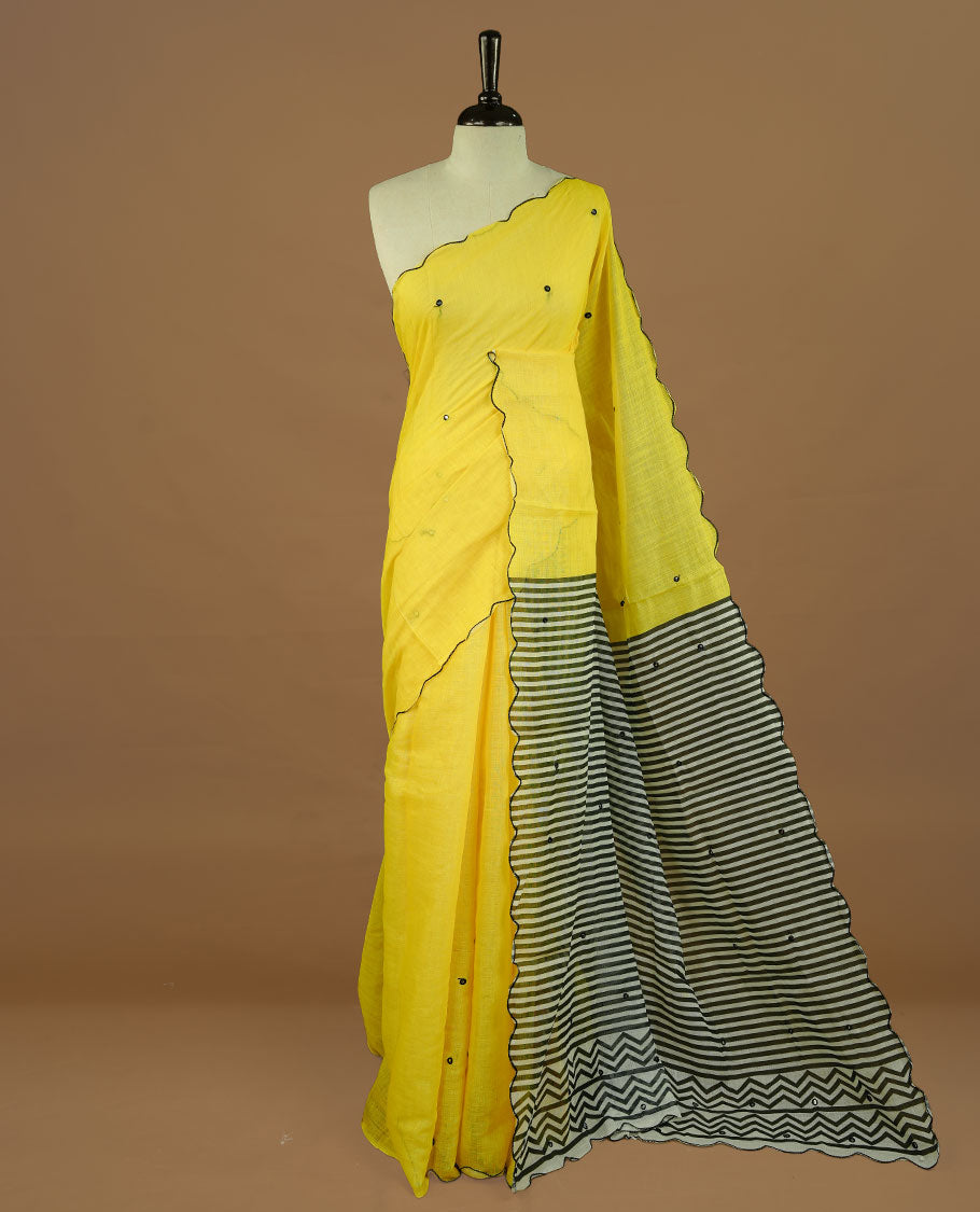 Yellow colour Semi Linen saree featuring mirror work with intricate thread detailing, enhanced by a stylish scallop border. Comes without a blouse piece.