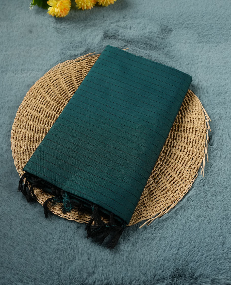 Teal Green colour poly cotton saree with black vertical dotted line pattern on the body, paired with a matching pallu featuring black zigzag geometric border, and a coordinated all‑over black stylised fleur‑de‑lis printed blouse piece.