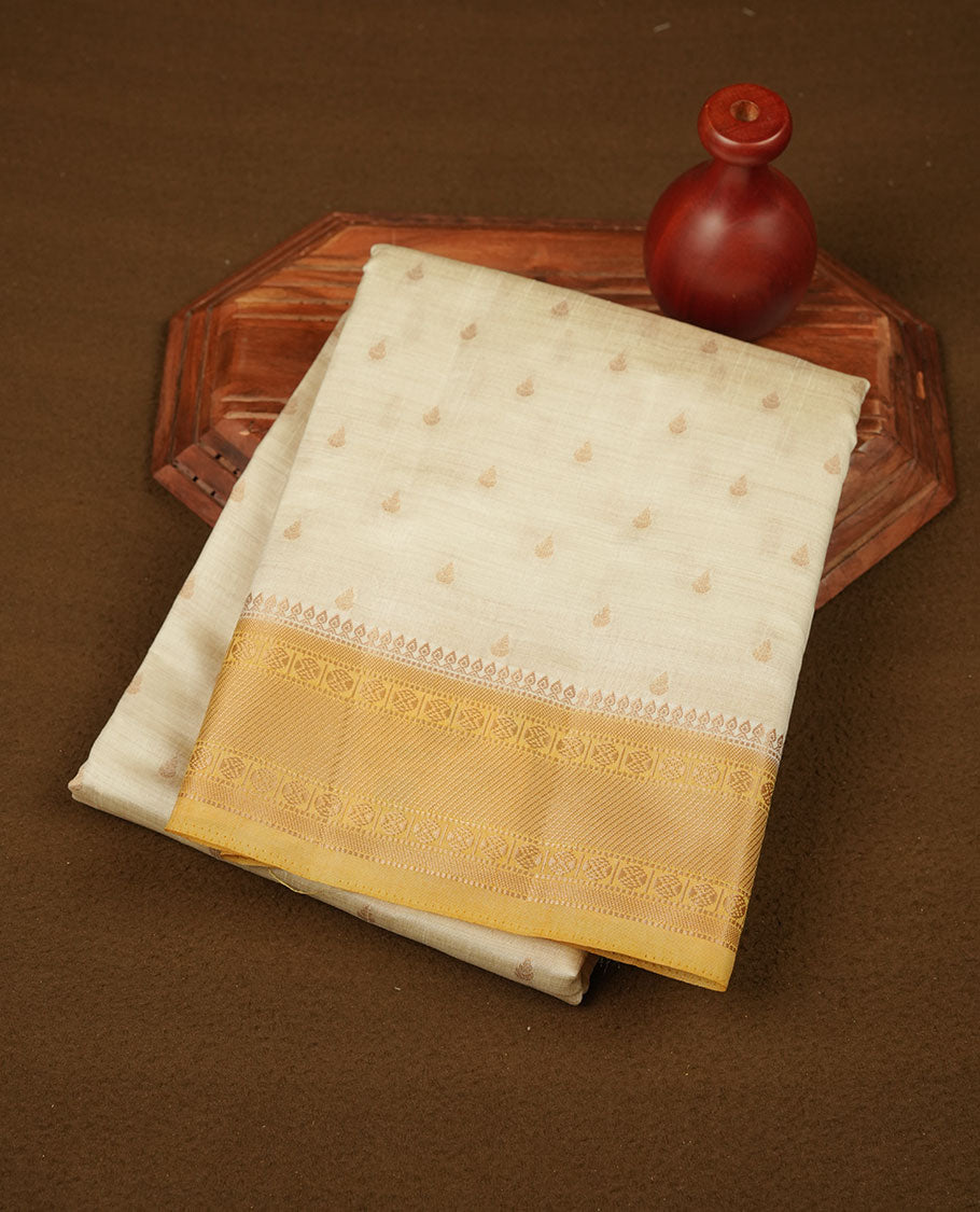 White gold colour semi tussar saree featuring Gold zari buttas body, contrast Yellow colour gold zari border and comes with matching blouse piece.