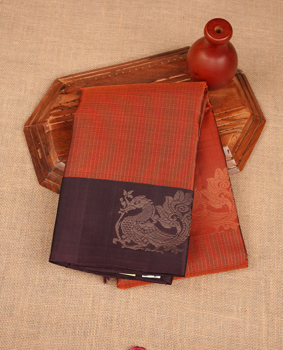Brick red colour soft silk saree featuring zari check on body, complemented by contrast burgundy colour with peacock buttas border, paired with matching.