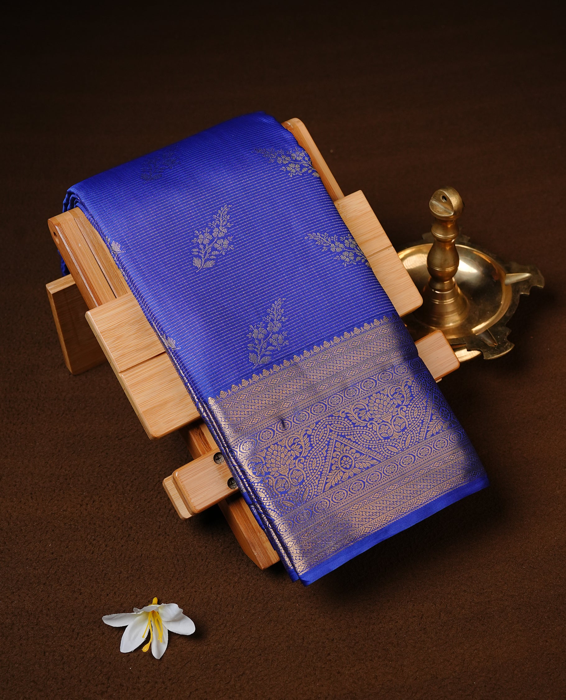 Blue Colour Semi Wedding Silk Saree Featuring Gold Zari stripes With Floral Buttas, Showcased with self colour With Traditional Border, Paired With Matching Blouse Piece.