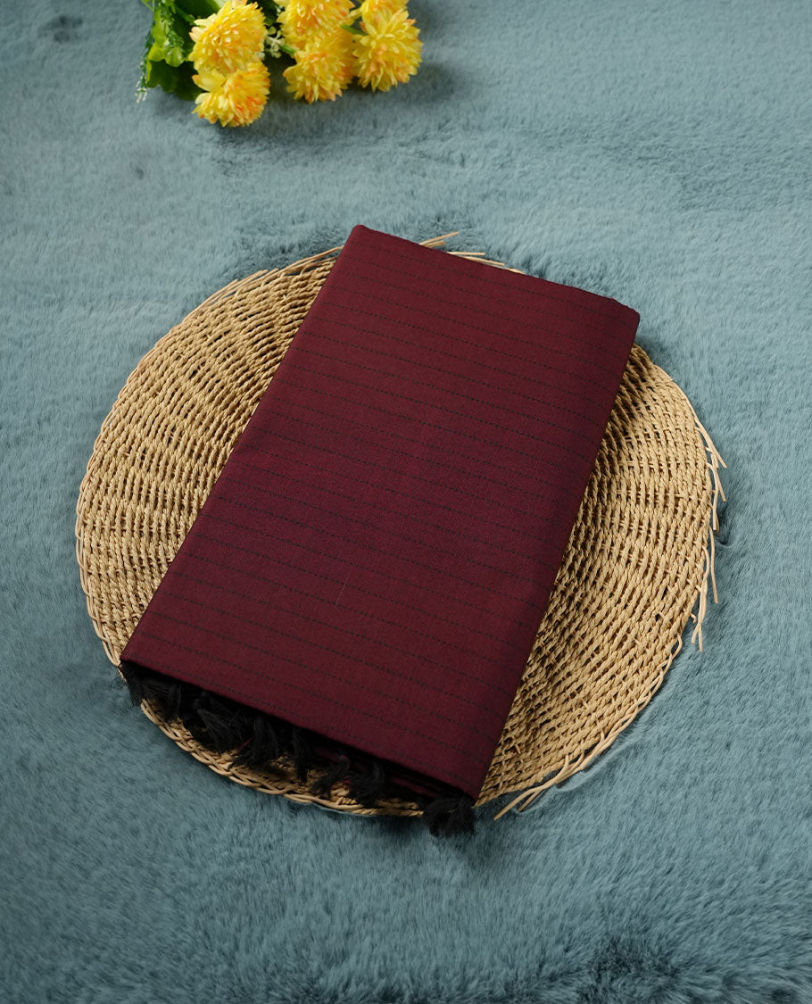 Dark Maroon colour poly cotton saree with black vertical dotted line pattern on the body, paired with a matching pallu featuring black zigzag geometric border, and a coordinated all‑over black stylised fleur‑de‑lis printed blouse piece.