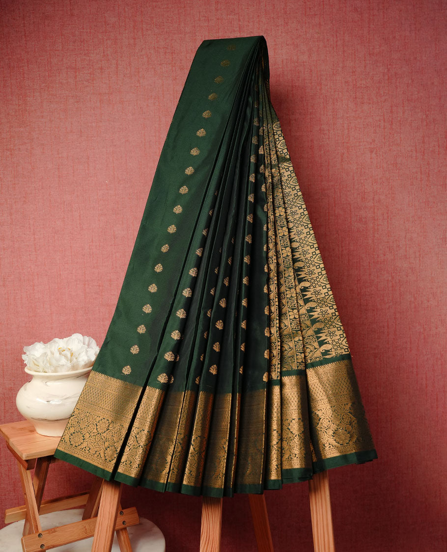 Dark green colour soft silk saree featuring gold zari motifs on body, complemented by self colour with traditional border, paired with matching blouse piece.