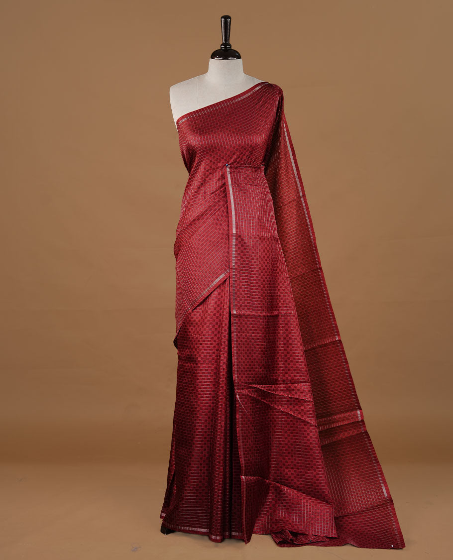 Maroon colour Semi Tussar saree featuring an elegant zari fancy check pattern on the body, highlighted with a small border for a refined look. Comes without a blouse piece.