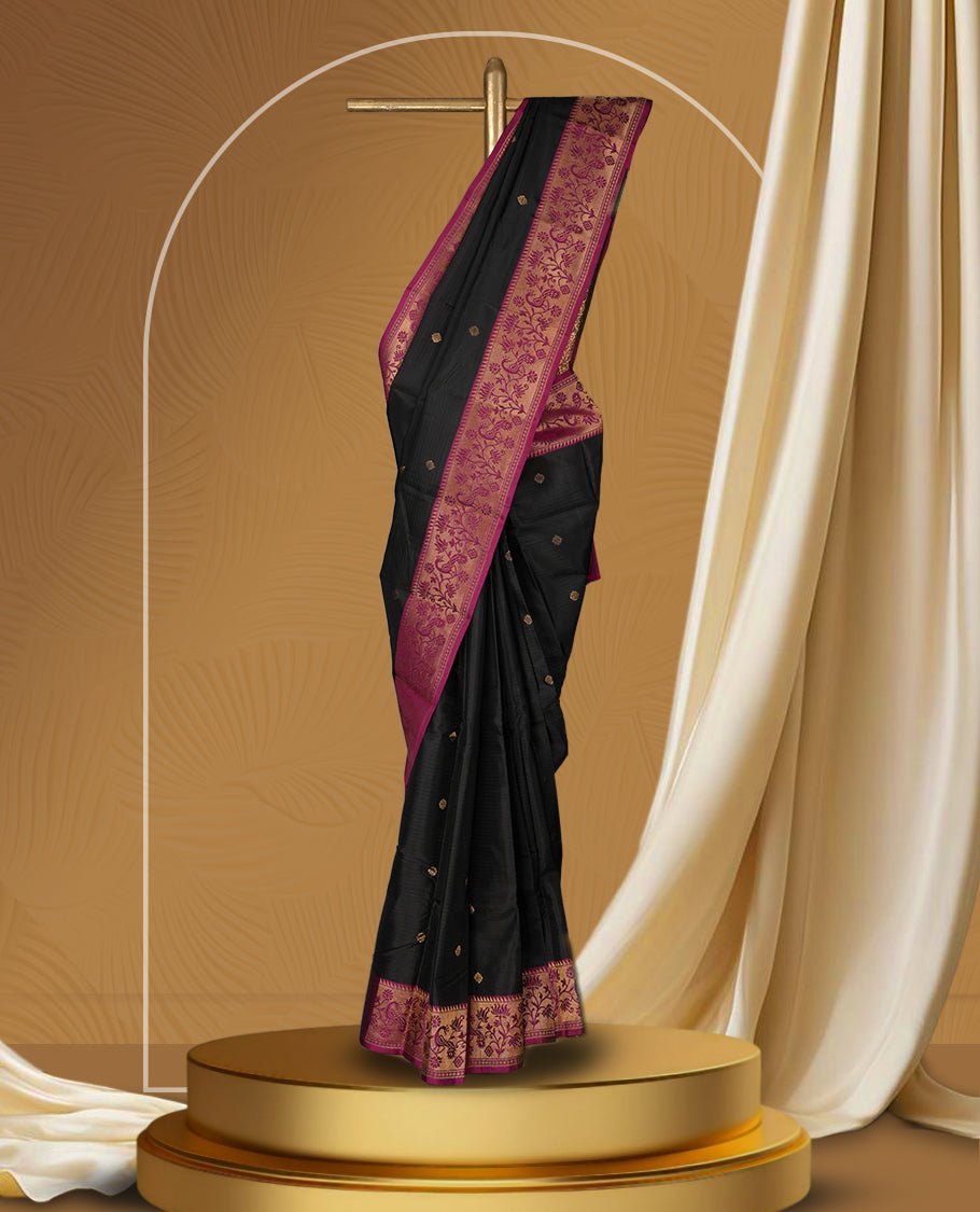 Black colour soft silk saree adorned with golden buttas, enhanced by a deep magenta border and pallu featuring intricate zari floral designs & Paired with a matching blouse.