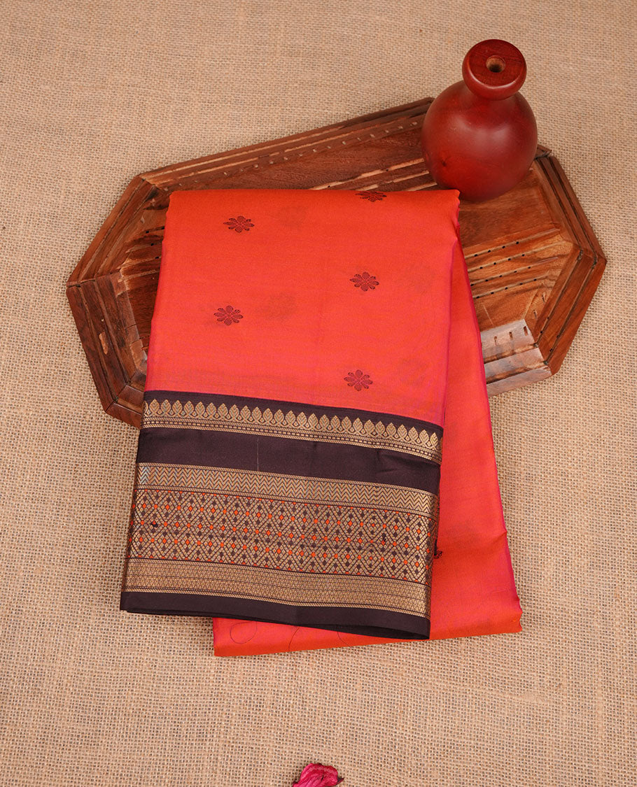 Burnt orange colour vasundhara silk sareee featuring zari buttas on body, complemented by contrast deep maroon colour with zari border, paired with matching blouse piece.