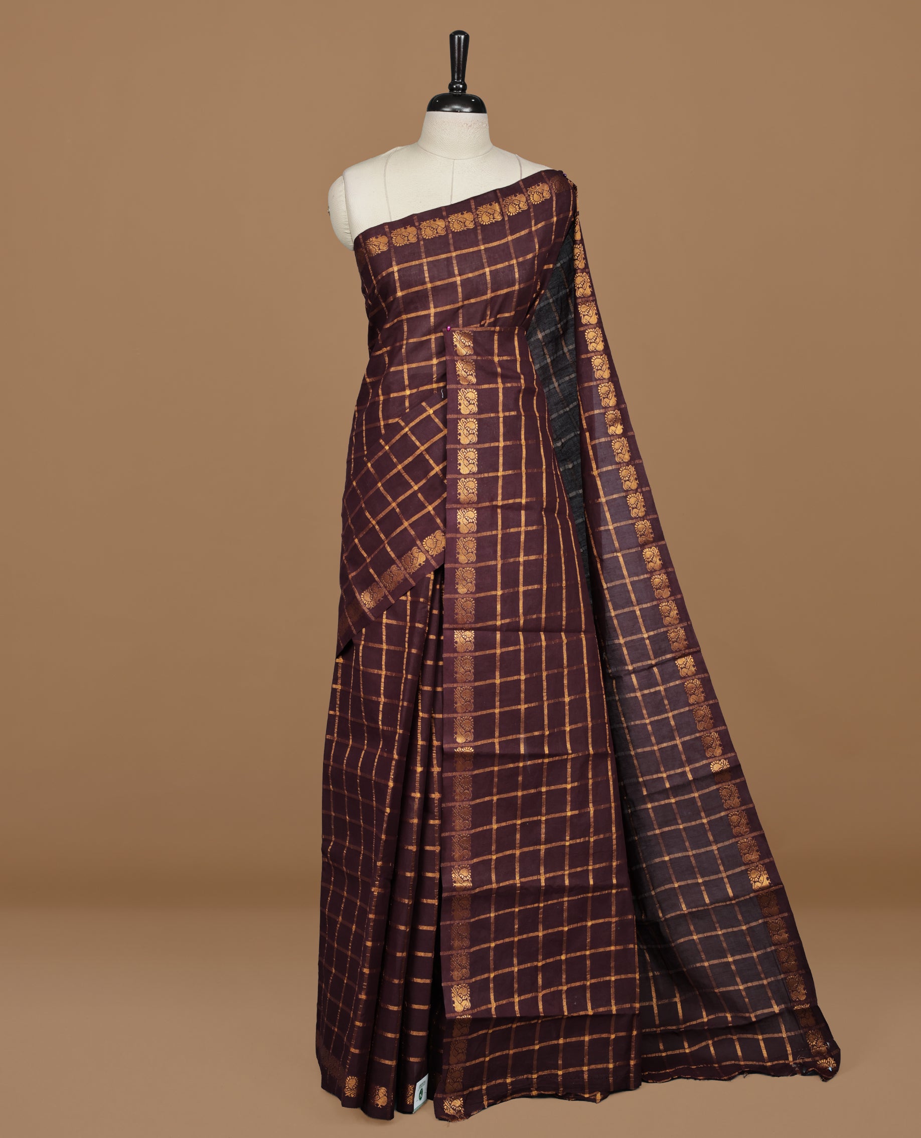 Dark chocolate colour Sungudi cotton saree featuring Gold zari Check pattern on body, Gold zari Peacock design on Self colour border, paired with matching blouse piece.