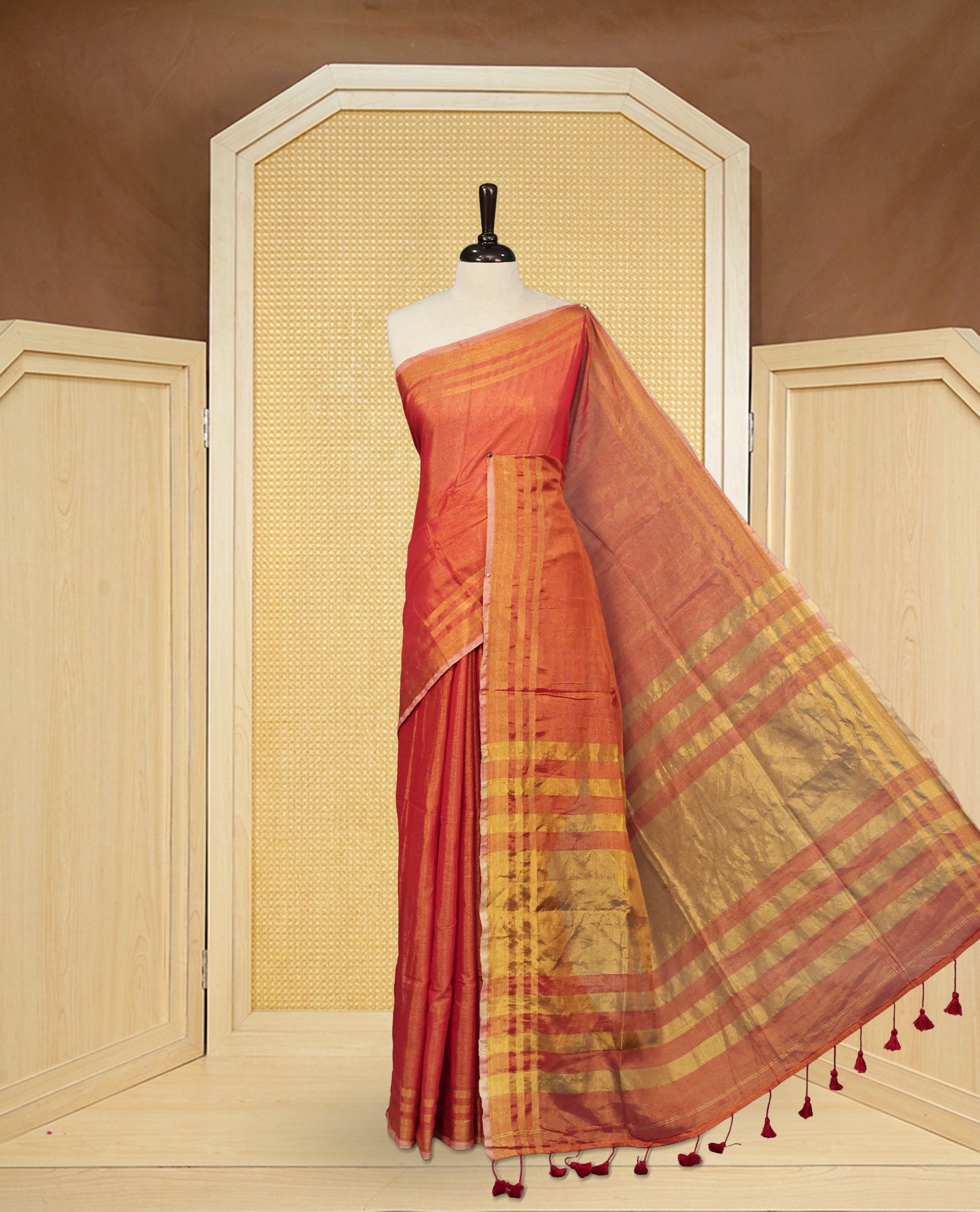 Red colour Semi Tissue Silk saree featuring Elegant plain body, Enhanced with Gold tissue Border & Striped Pallu & beautiful Tassels for Elegant Prefect Look.