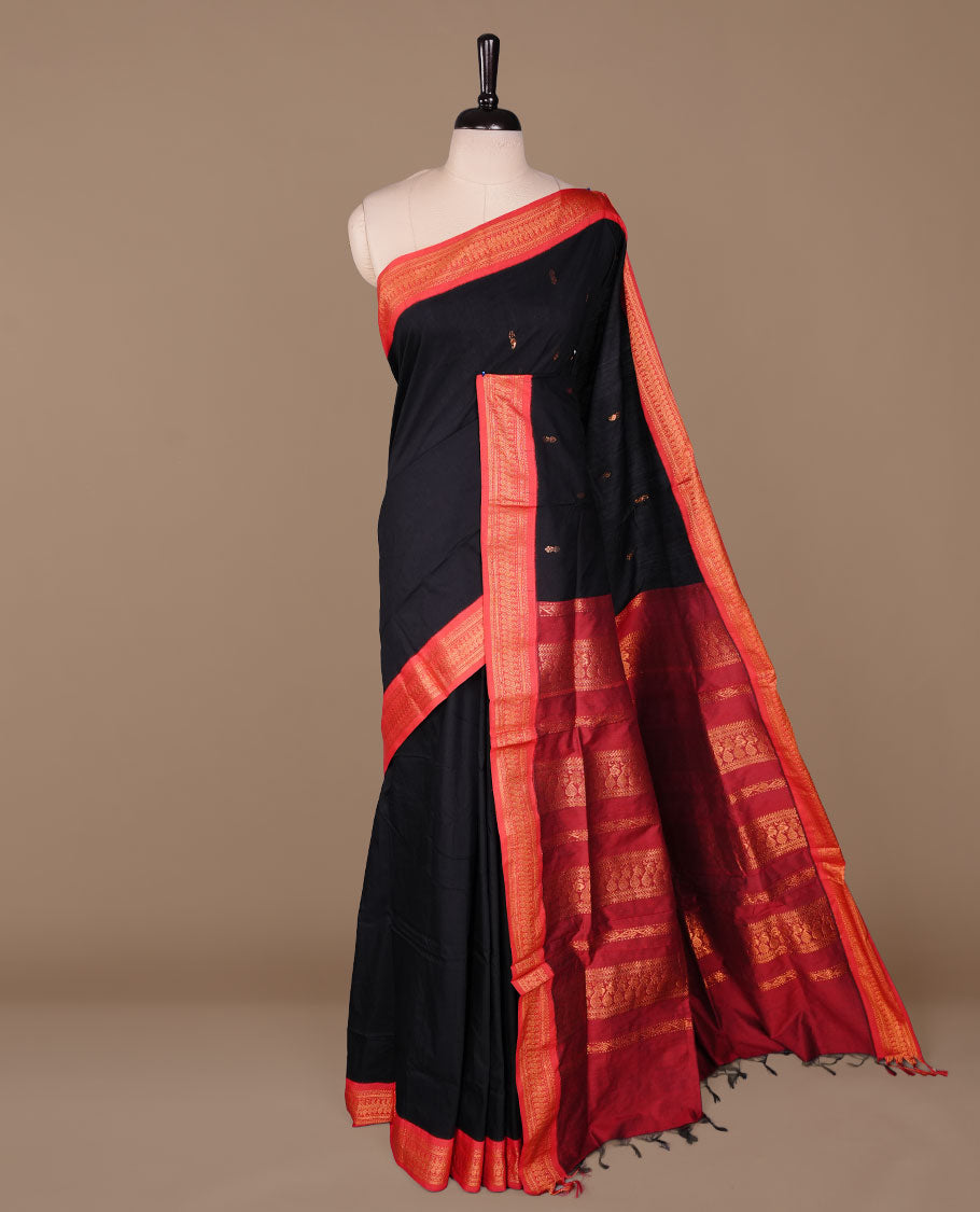 Black colour kalyani cotton saree featuring antique zari motifs on body, complemented by red colour with Antique zari border, paired with matching blouse piece.