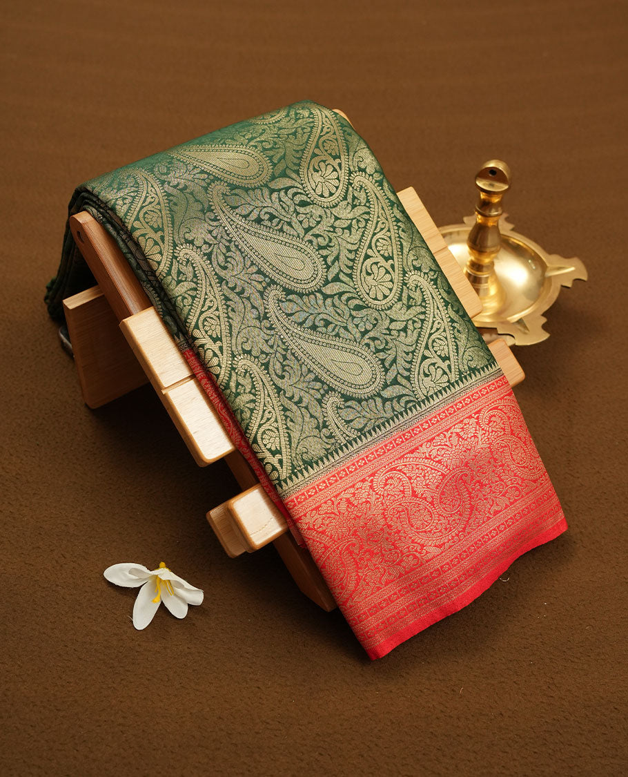 Green colour semi silk brocade saree featuring intricate Gold Floral kodi & leaf patterns across the body, complemented by a contrast red colour woven border and pallu, paired with a matching blouse.