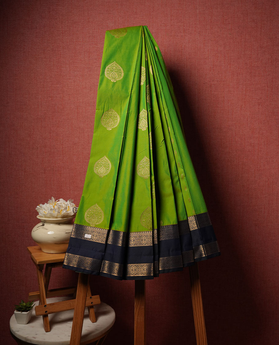 Lemon green colour semi silk saree highlighting gold zari motifs across body, featuring contrast dark blue colour border with gold zari pattern, comes with matching blouse .