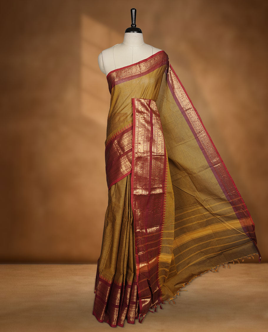 Mustard colour chettinad cotton saree featuring plain body, paired with a black colour traditional gold zari border paired with matching blouse.