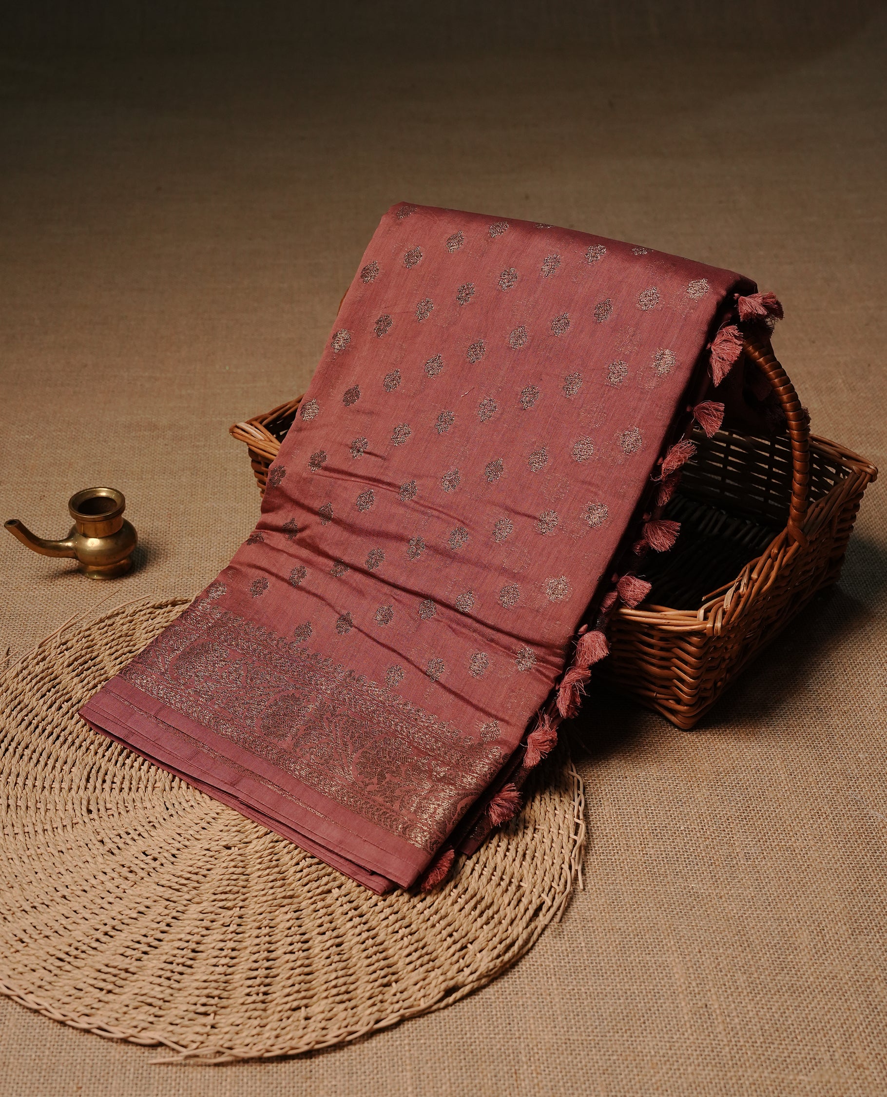 Muted brown colour semi tussar silk saree featuring elegant Antique zari motifs across the body, designed with a subtle borderless zari finish for a sophisticated traditional look. Paired with a matching blouse piece.