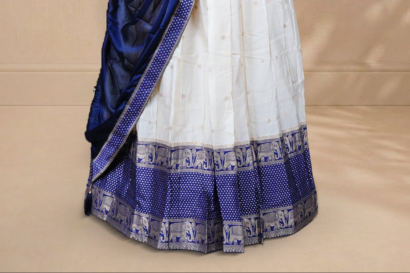 Cream colour Half saree featuring Gold zari buttas on skirt with Zari border on contrast Blue colour border, Unstitched Blouse and matching dupatta.