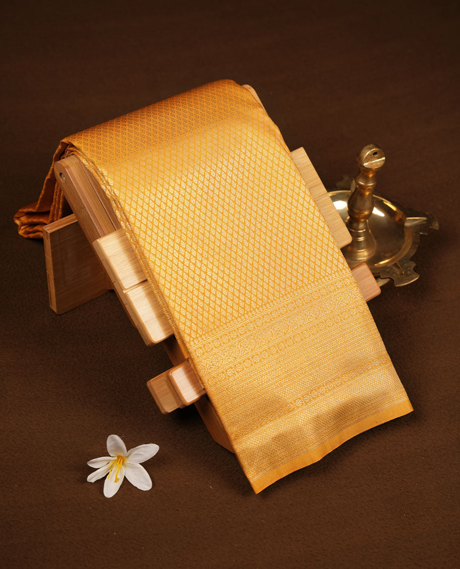 Golden mustard colour semi soft silk brocade saree featuring elegant self-woven motifs across the body, enhanced with a neatly detailed woven border and pallu, paired with a matching blouse.