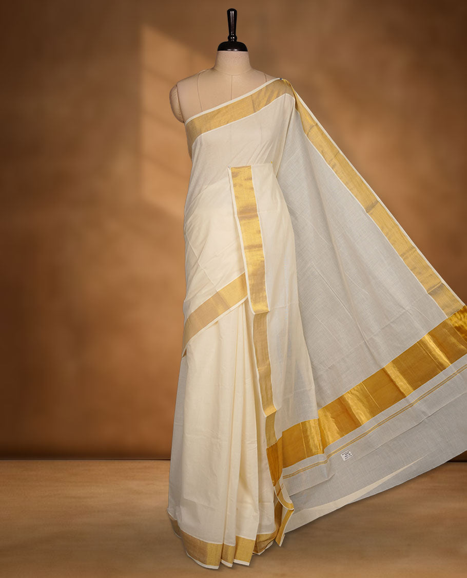 Off-white colour cotton Kerala saree crafted in a soft, sheer weave, finished with a classic gold kasavu border along the body and pallu, and paired with a matching blouse.