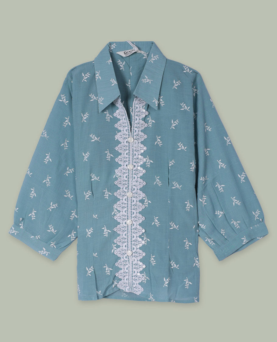 Dusty teal shirt top with all-over tiny white sprig print, collared neckline, three-quarter sleeves, and front button placket framed by a wide scalloped lace panel.