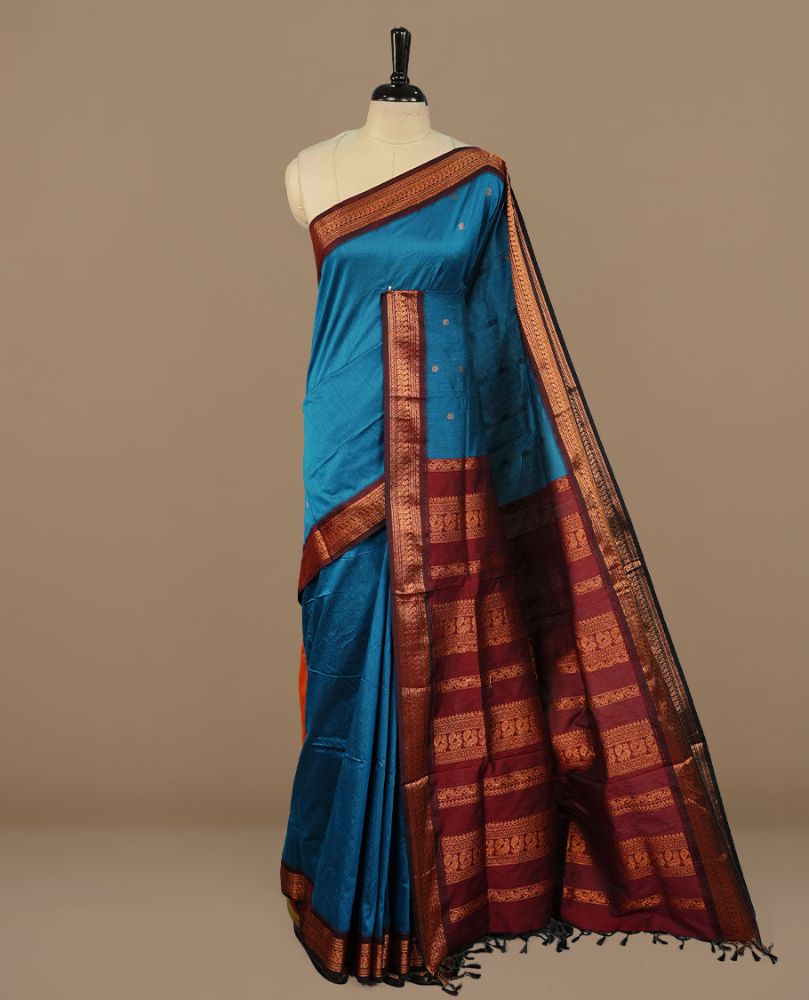 Blue colour kalyani cotton saree featuring antique zari motifs on body, complemented by Maroon colour with Antique zari border, paired with matching blouse piece.
