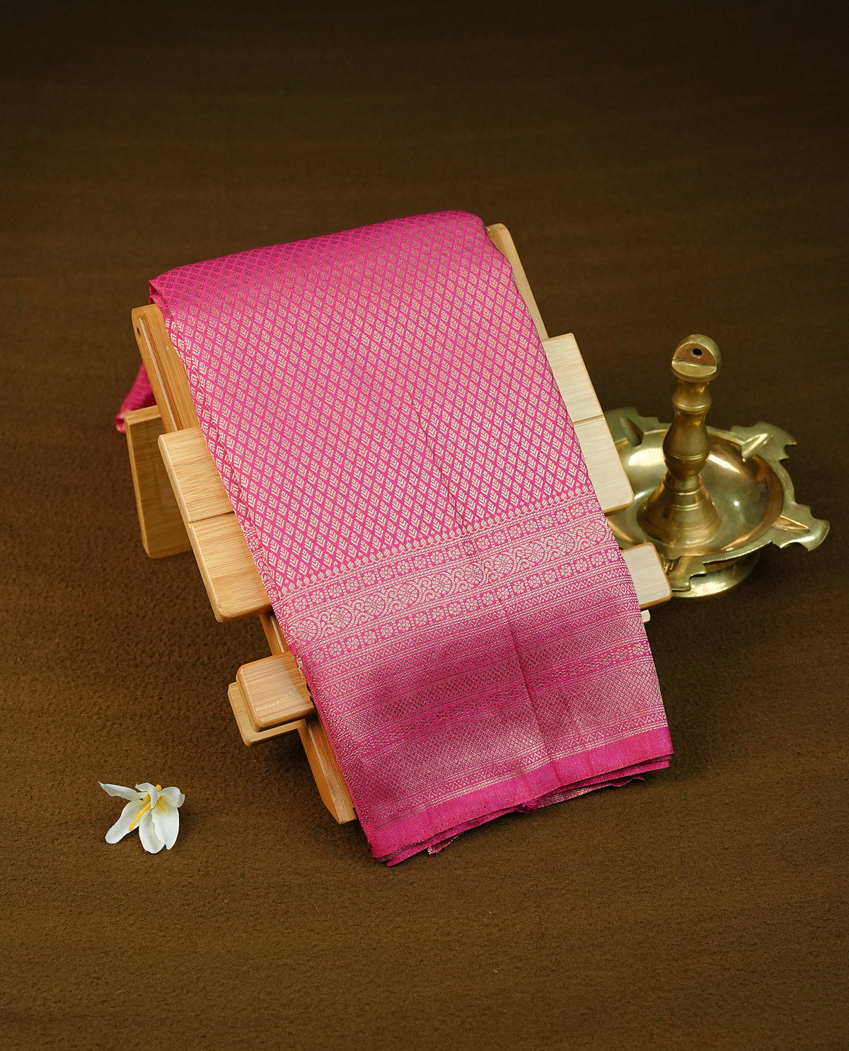 Magenta colour semi wedding saree featuring light gold zari diamond motifs across the body, complemented by a contrast magenta traditional border. Comes with a matching blouse piece.