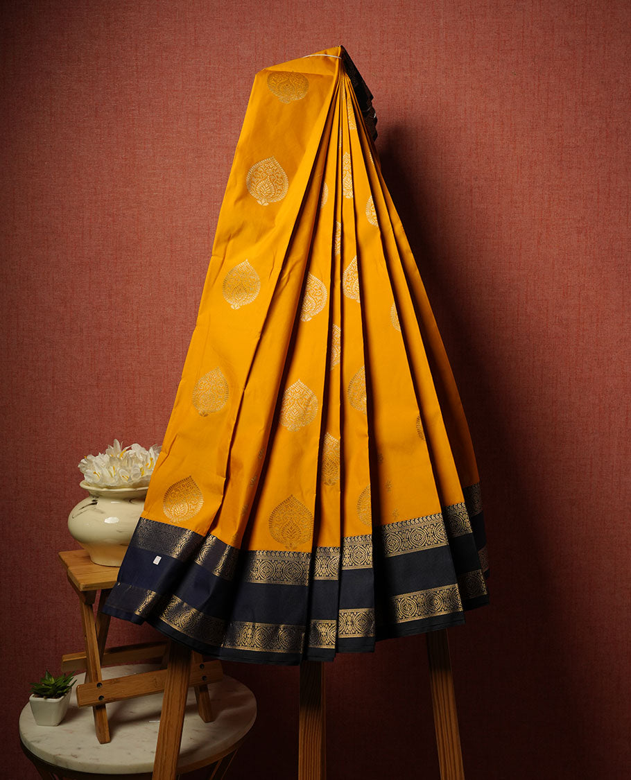 Mustard colour semi silk saree highlighting gold zari motifs across body, featuring contrast Dark blue colour border with gold zari pattern, comes with matching blouse .