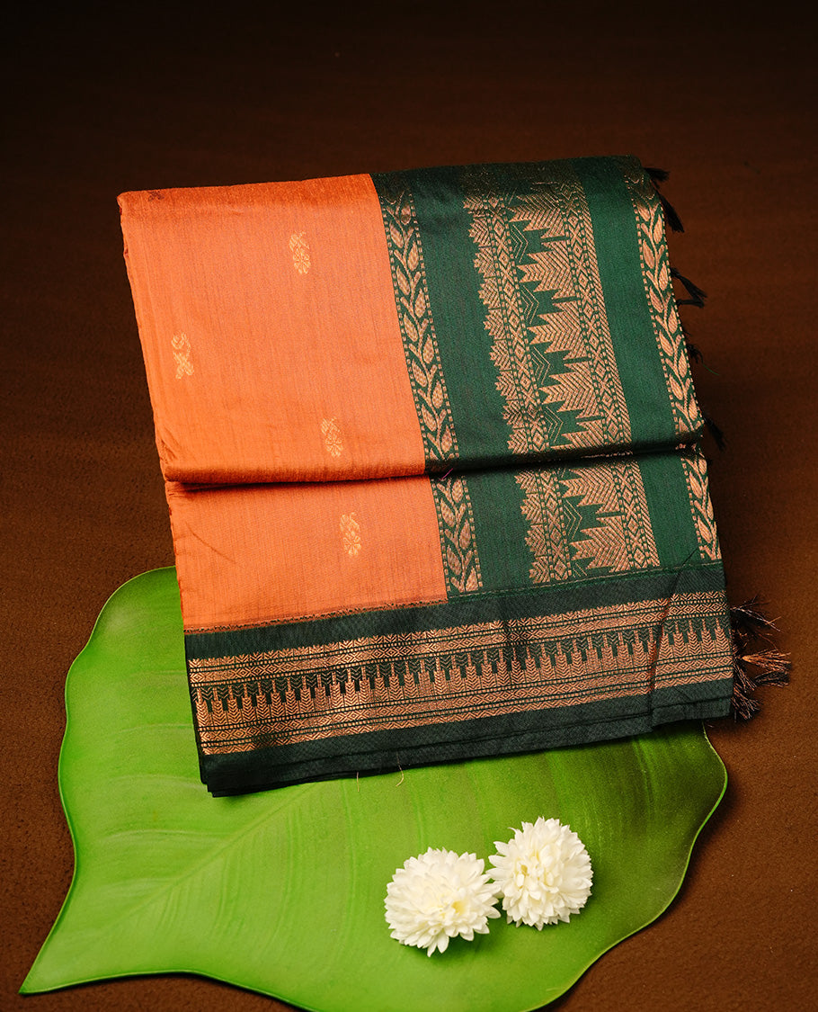 Orange colour kalyani cotton saree featuring gold zari motifs on body, highlighting contrast green colour with Antique gold zari border, paired with matching blouse piece.