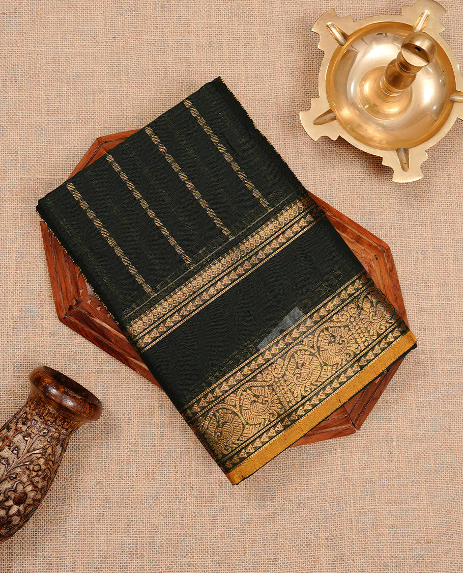 Dark green colour chettinad cotton saree featuring gold zari stripes on body, complemented by self colour with zari mustard piping border, paired with matching blouse piece.
