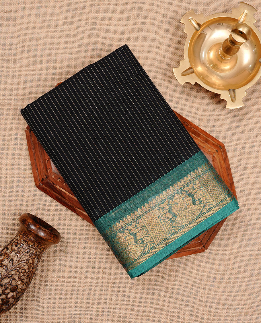 Black colour chettinad cotton saree featuring gold zari stripes on body, complemented by Green colour with zari border, paired with matching blouse piece.