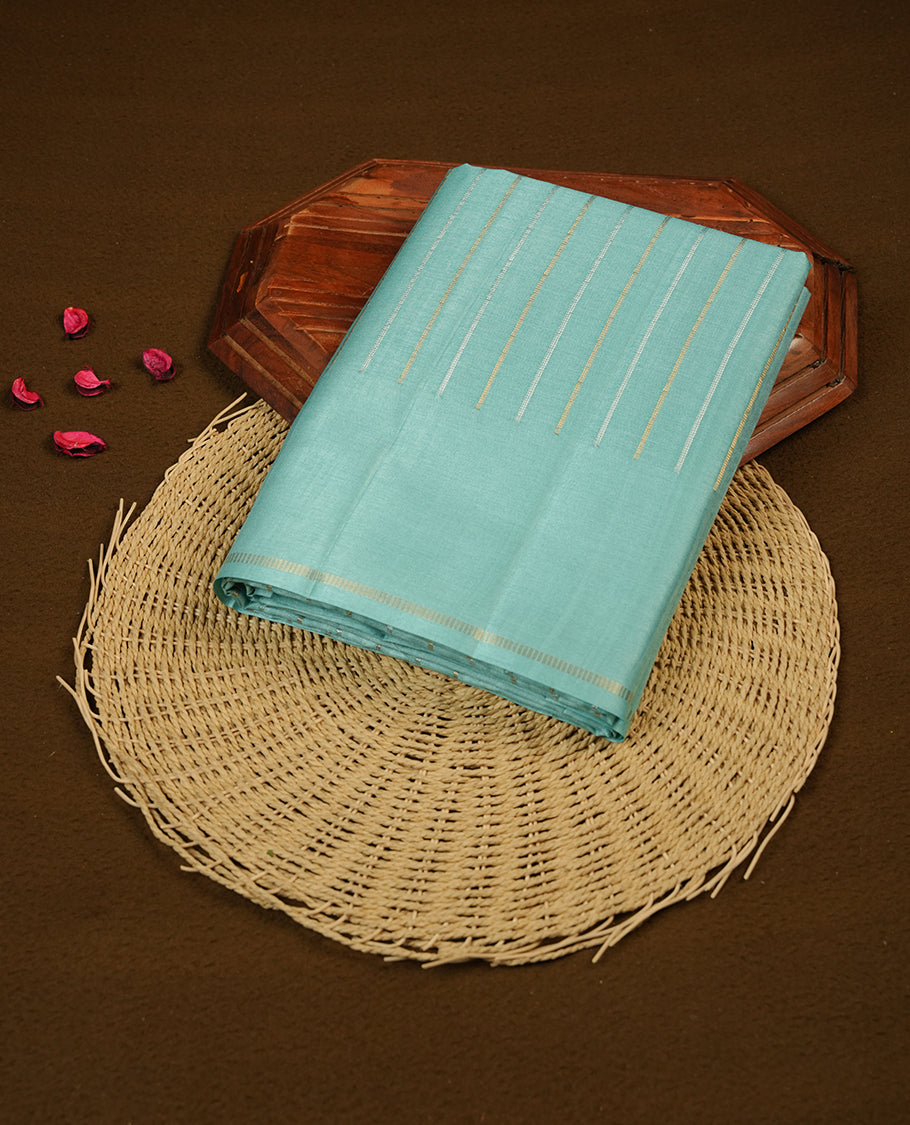 Pastel aqua colour semi tussar silk saree highlights gold and silver zari stripes across body, border, pallu and paired with matching blouse piece.