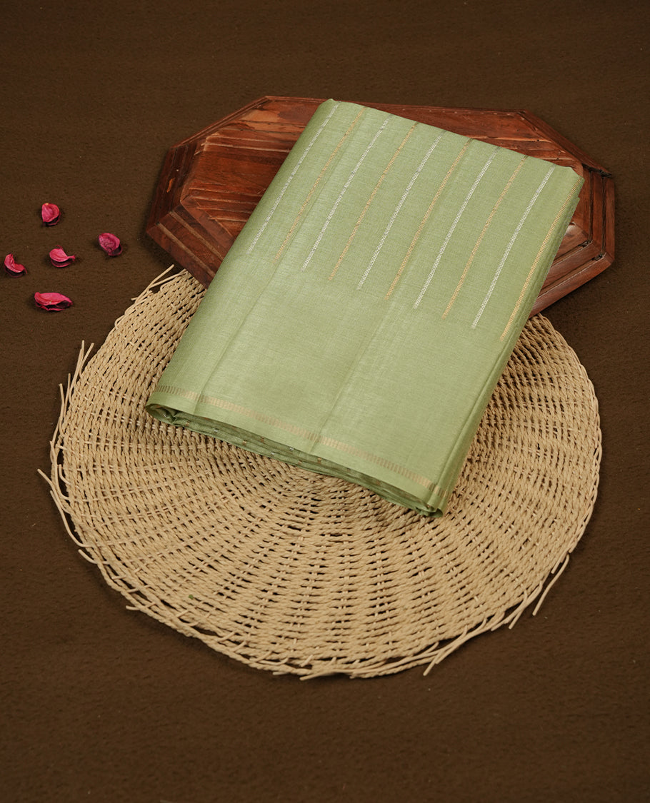 Pastel green colour semi tussar silk saree highlights gold and silver zari stripes across body, border, pallu and paired with matching blouse piece.