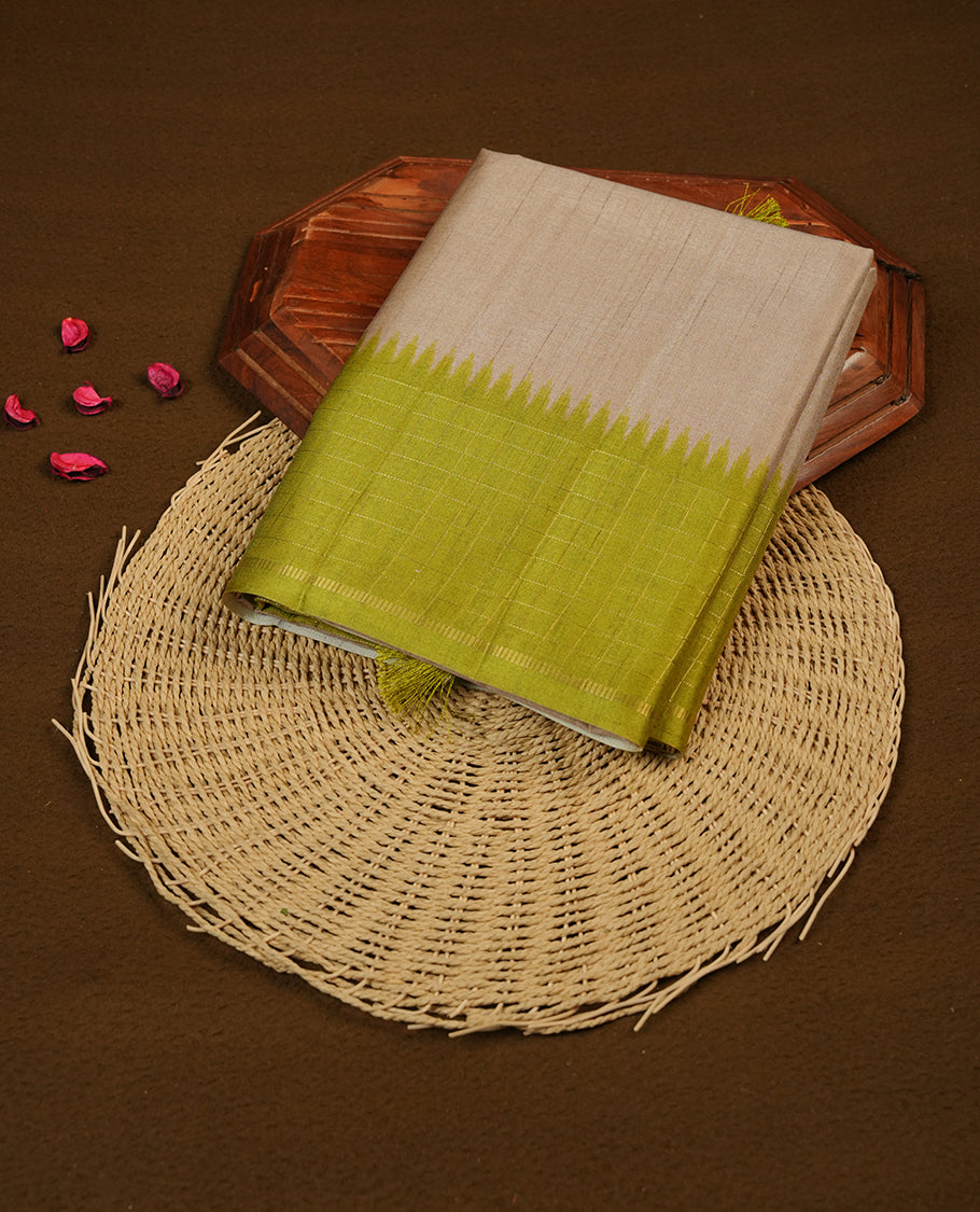 Beige colour semi tussar saree highlighting elegant plain body, contrast green colour border with gold zari box pattern, pallu and comes with matching blouse piece.