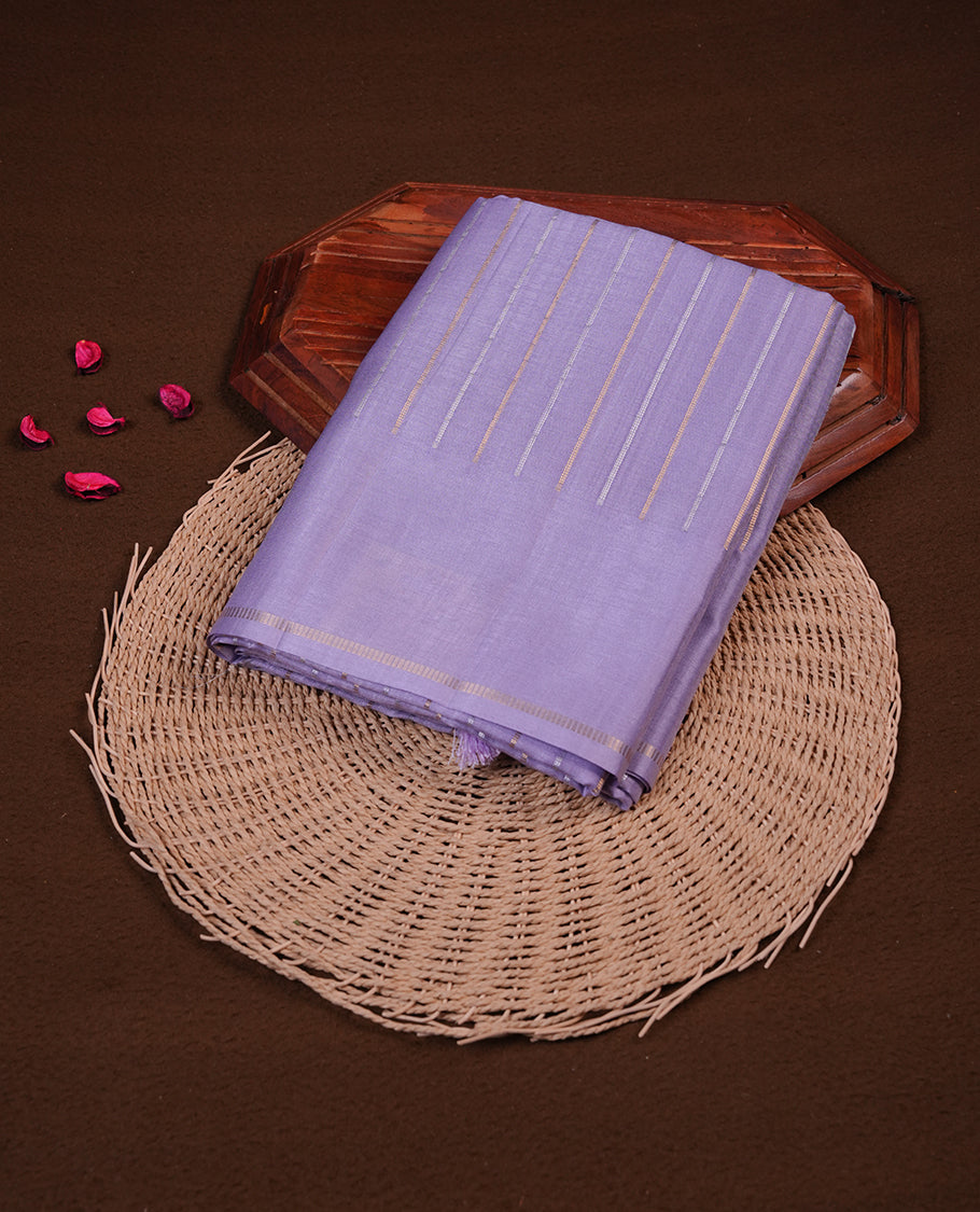 Pastel lavender colour semi tussar silk saree highlights gold and silver zari stripes across body, border, pallu and paired with matching blouse piece.