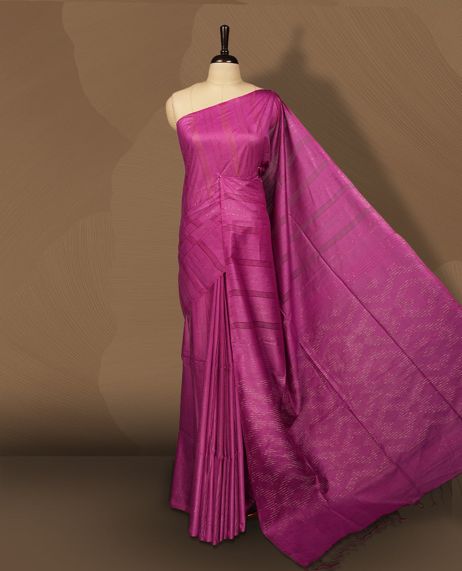 Magenta colour semi jute saree featuring subtle woven patterns and fine thread striped detailing, finished with tassels on the pallu & Comes with a matching blouse piece for a graceful traditional look.
