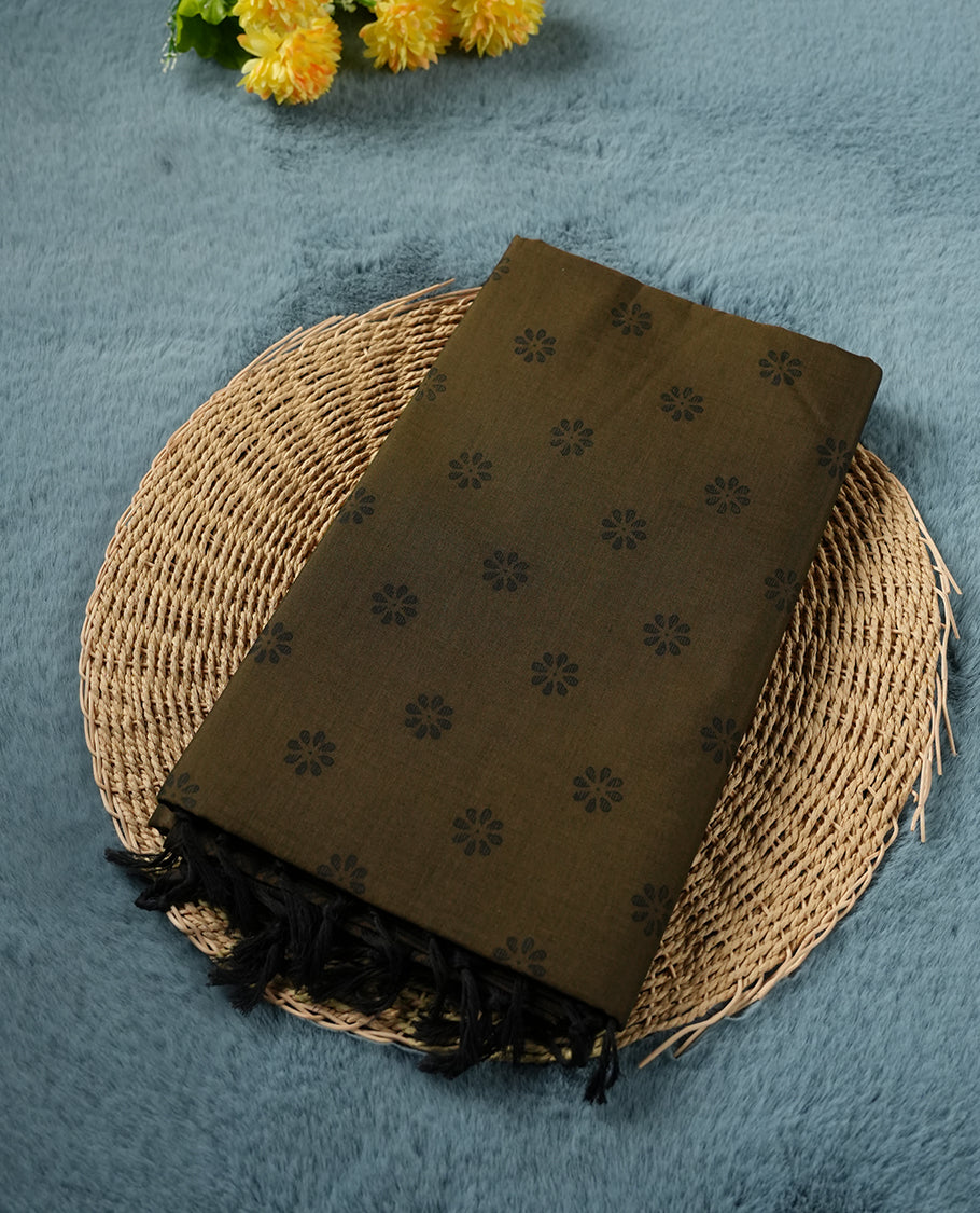 Dark Brown colour poly cotton saree with black floral butti motifs on the body, paired with a matching pallu featuring black ornate floral jaal and stripes on the border, and a coordinated all‑over black paisley printed blouse piece.