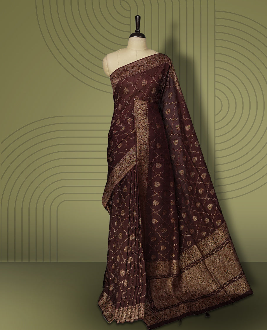 Coffee brown colour semi Banarasi Tussar Georgette saree with gold zari motifs on the body, a grand woven golden pallu, and ornate zari border. Includes a matching blouse piece for a complete look.