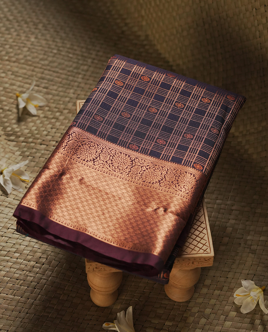 Dark blue colour Semi Silk Saree with copper zari checkered on the body, paired with a contrast chocolate brown colour pallu with copper zari traditioal border, and a matching blouse piece.