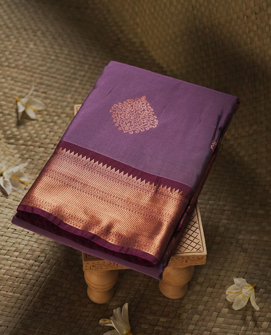 Light purple colour Semi Silk Saree with gold zari motifs on the body, paired with a contrast Wine colour pallu with copper zari traditioal border, and a matching blouse piece.