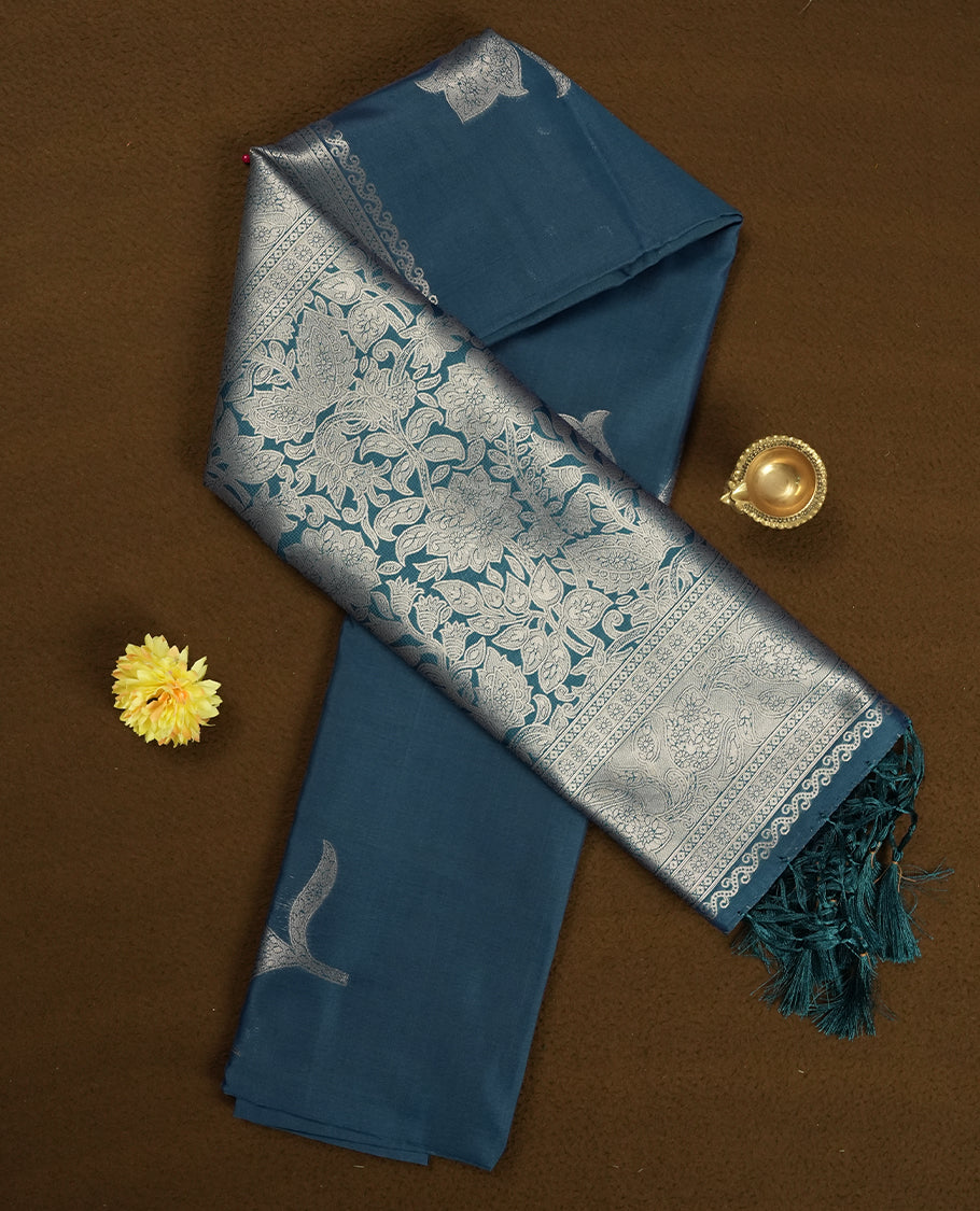 Teal Blue Semi Silk Saree with Silver Zari Floral Woven Pallu and Border, Subtle Zari Butta Motifs on the Body, Tassel Detailing, and Coordinated Blouse Piece