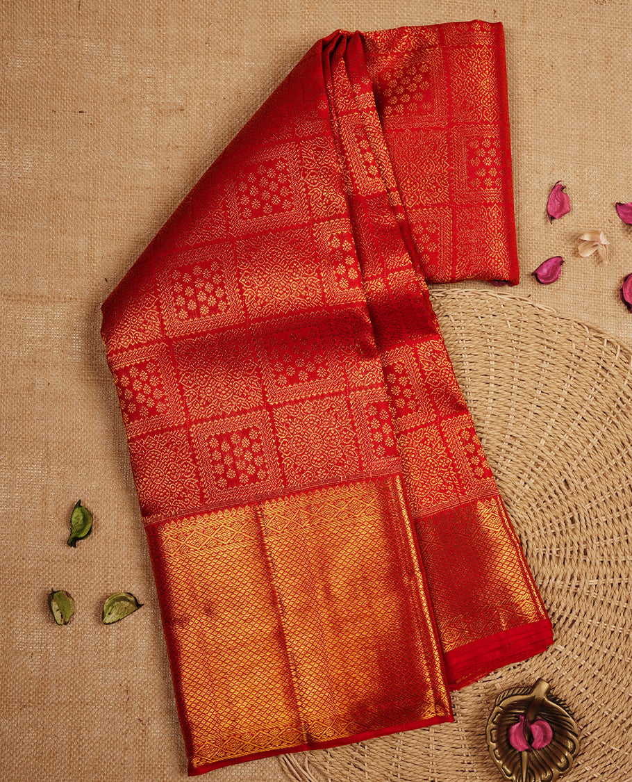 Deep red colour Kanchipuram Samudrika Silk Saree featuring Floral in square pattern weaving with gold zari jacquard and a traditional Kanchipuram zari border, paired with a matching designer jacquard blouse piece