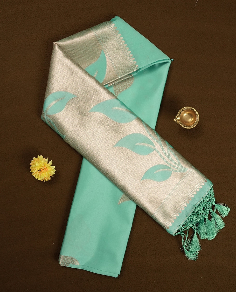 Mint green colour semi silk saree adorned with elegant floral motifs on the body, complemented by a shimmering golden zari-woven pallu and border, and paired with a matching blouse