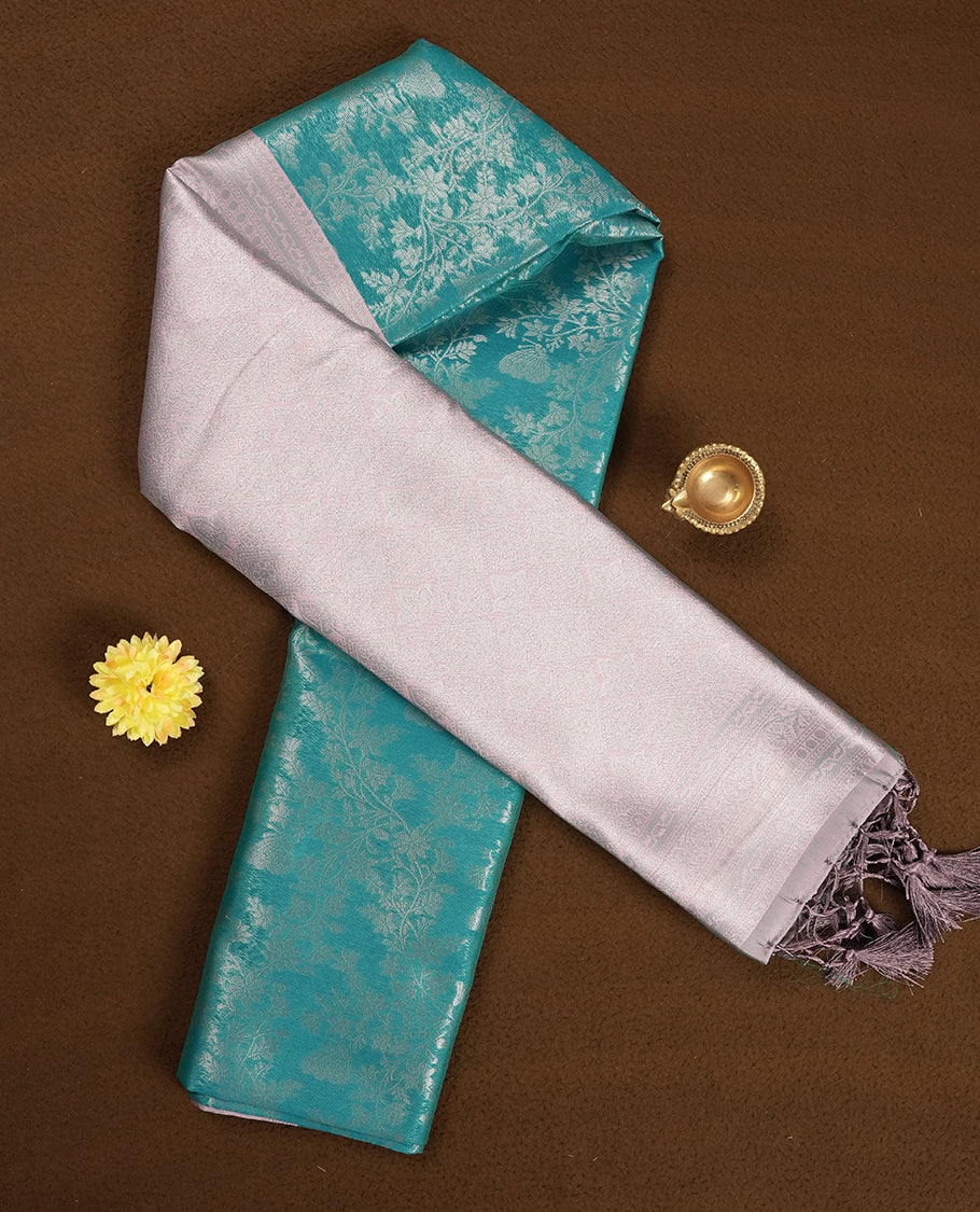 Aqua blue colour semi silk saree adorned with silver zari designs on the body, complemented by a contrasting Aqua blue border and pallu, and paired with a matching blouse piece