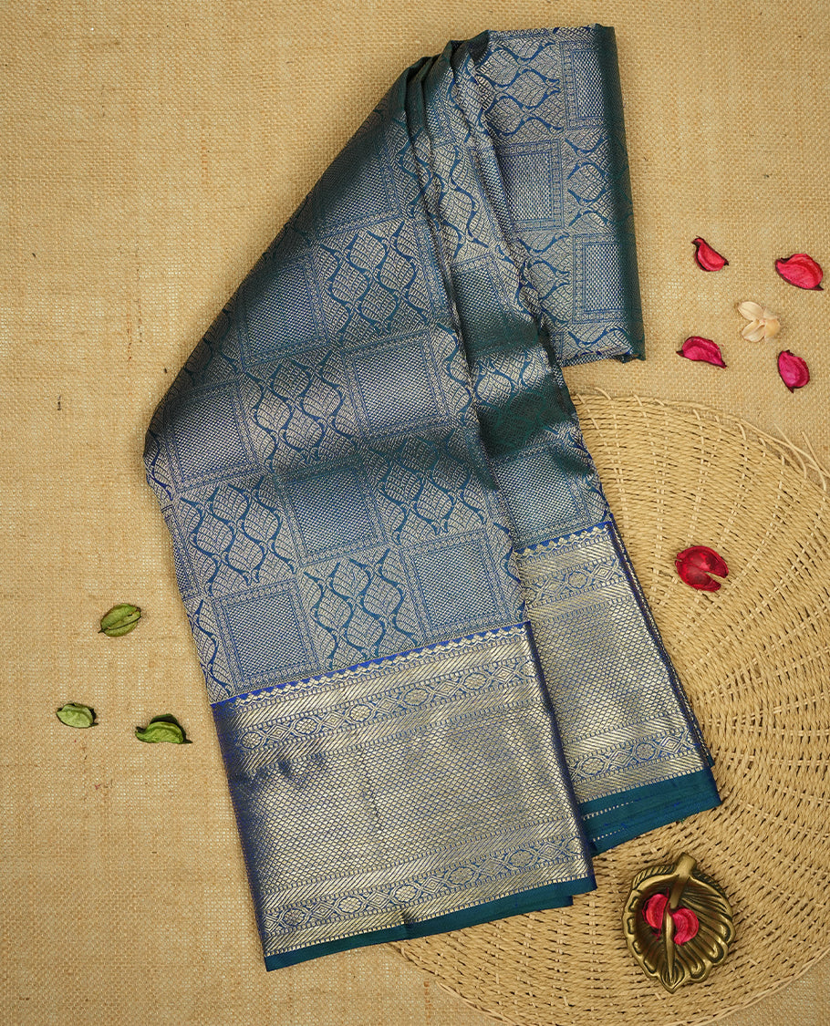 Peacock colour Kanchipuram Samudrika Silk Saree featuring Leaf & square pattern weaving with Light gold zari jacquard and a traditional Zari border, paired with a matching designer jacquard blouse piece