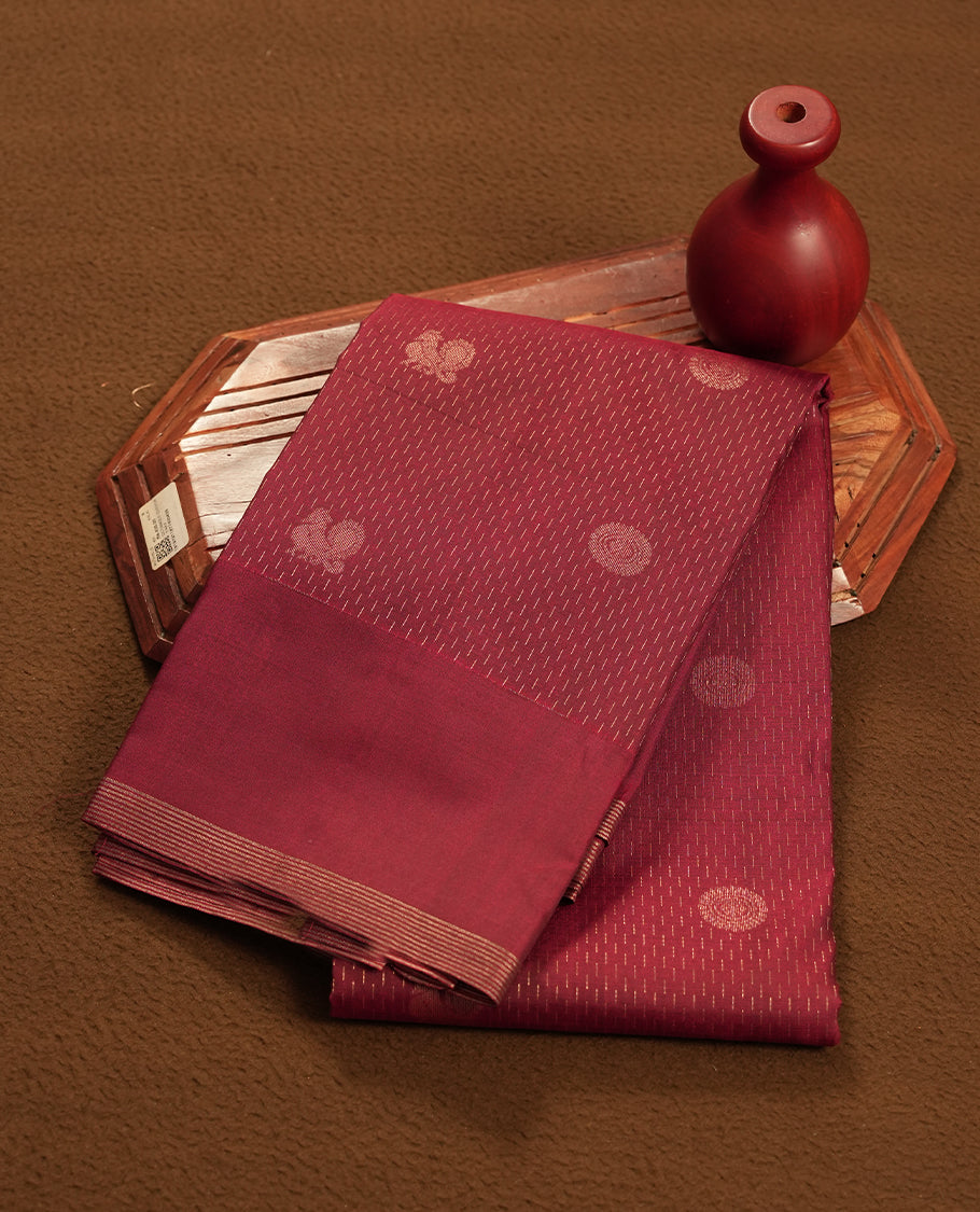 Dark maroon colour semi soft silk saree featuring a self coloured golden textured patterned body, complemented by self coloured pallu & golden border and a matching blouse piece.