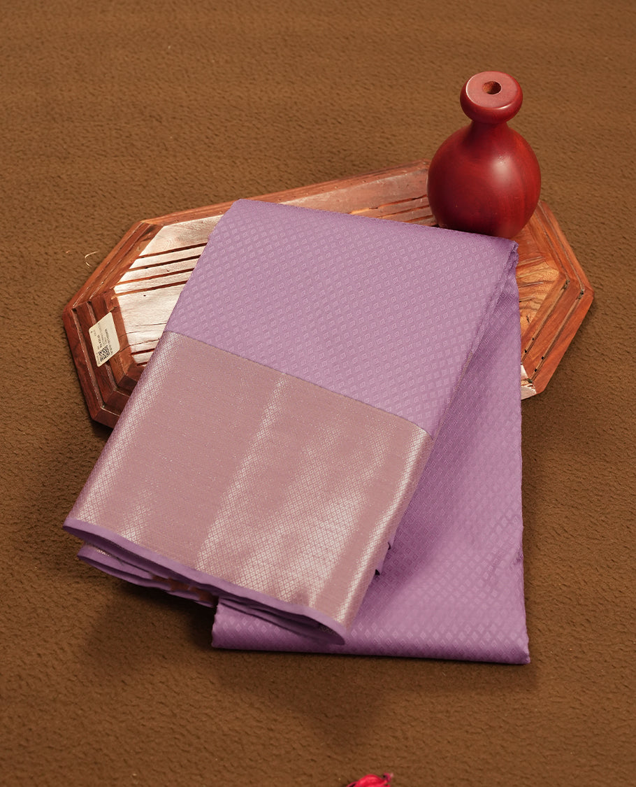 Purple Lavender colour semi soft silk saree featuring a self coloured textured patterned body, complemented by self coloured silver motifes on pallu & border and a matching blouse piece.