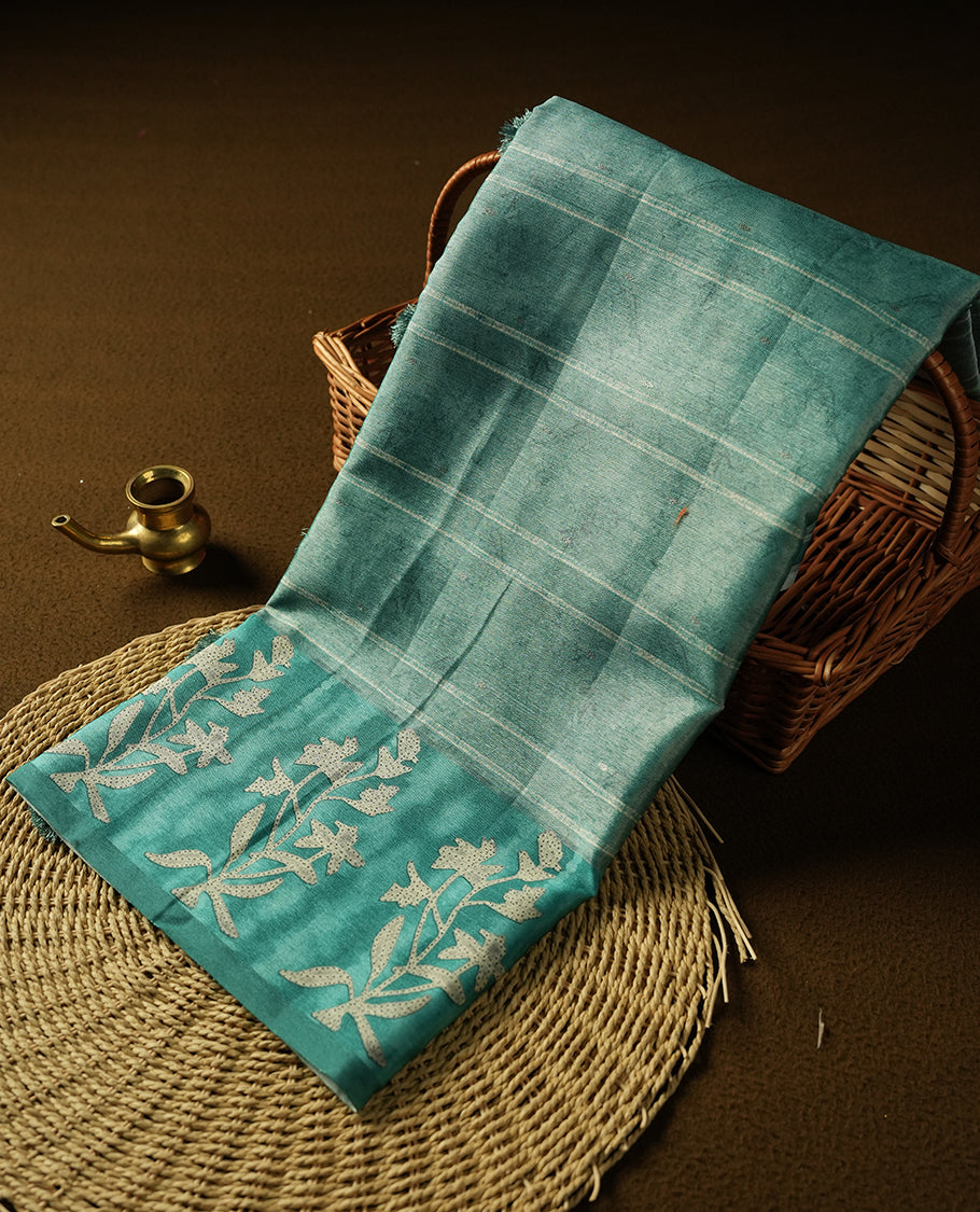 Light Aqua green colour semi tussar saree adorned with Cream strip printed pattern across the body and Floral pattern contrast Aqua green colour on border, paired with a matching blouse.