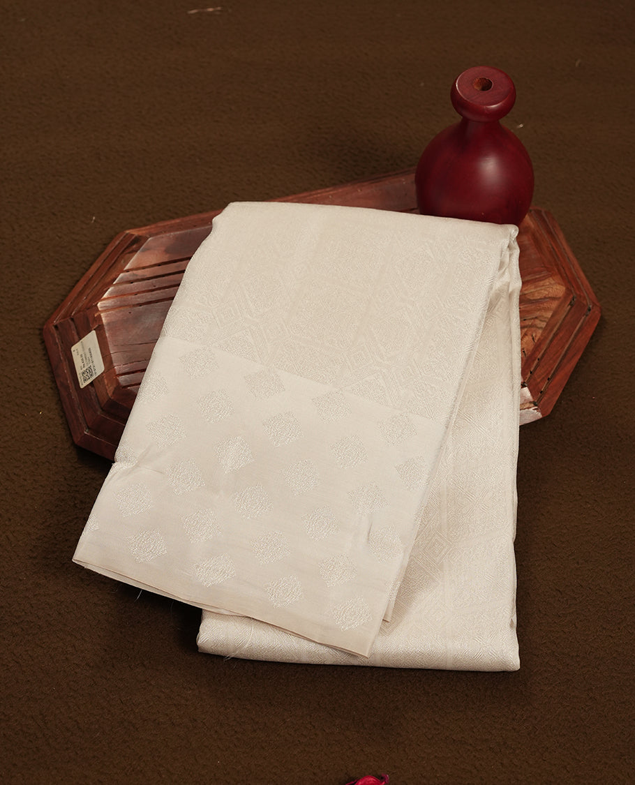 Off white colour semi soft silk saree featuring a self coloured textured patterned body, complemented by self coloured Square motifs on pallu & border and a matching blouse piece.