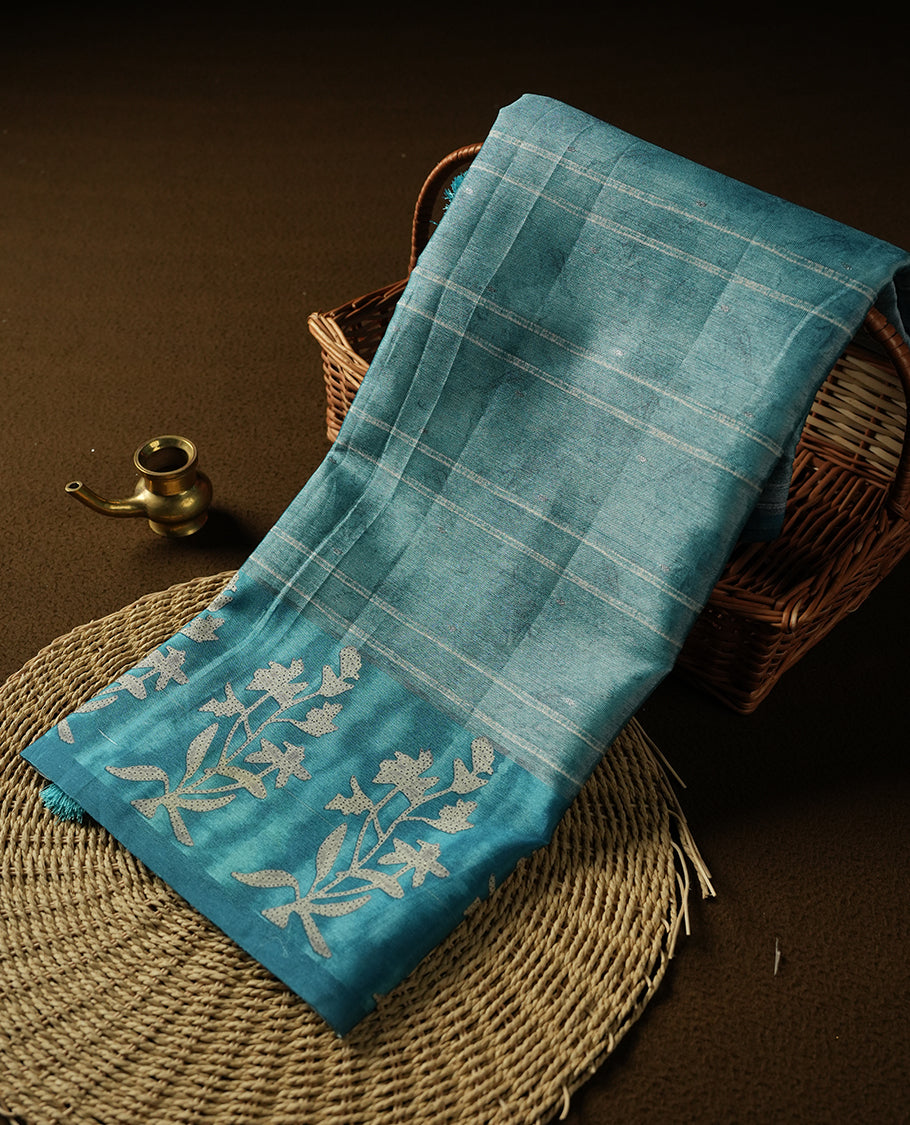 Light Aqua Blue colour semi tussar saree adorned with Cream strip printed pattern across the body and Floral pattern contrast Aqua Blue colour on border, paired with a matching blouse.