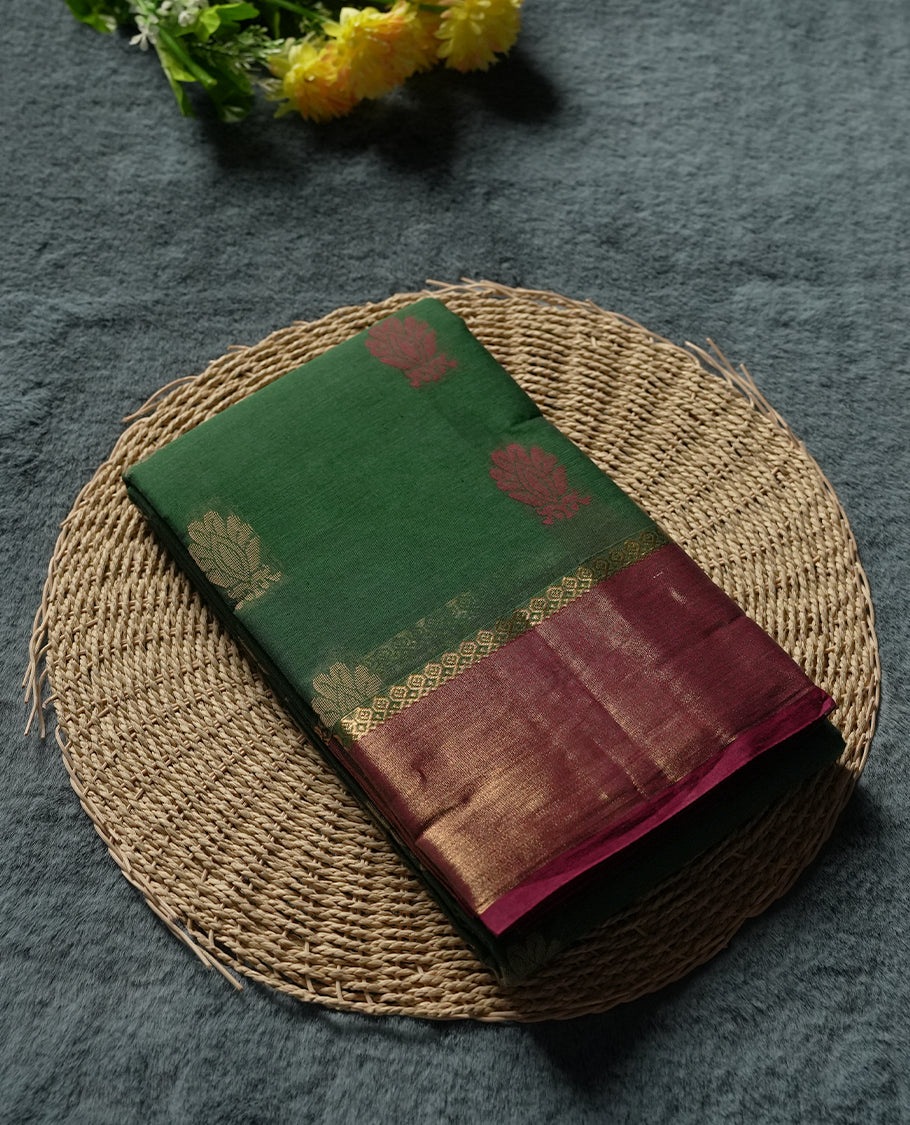 Emerald Green colour Silk Cotton Saree with Dual-Tone Zari Butta Motifs on the Body, Contrasting Antique Gold Tissue Border Accented with Maroon Selvedge, and a Coordinated Matching Blouse Piece