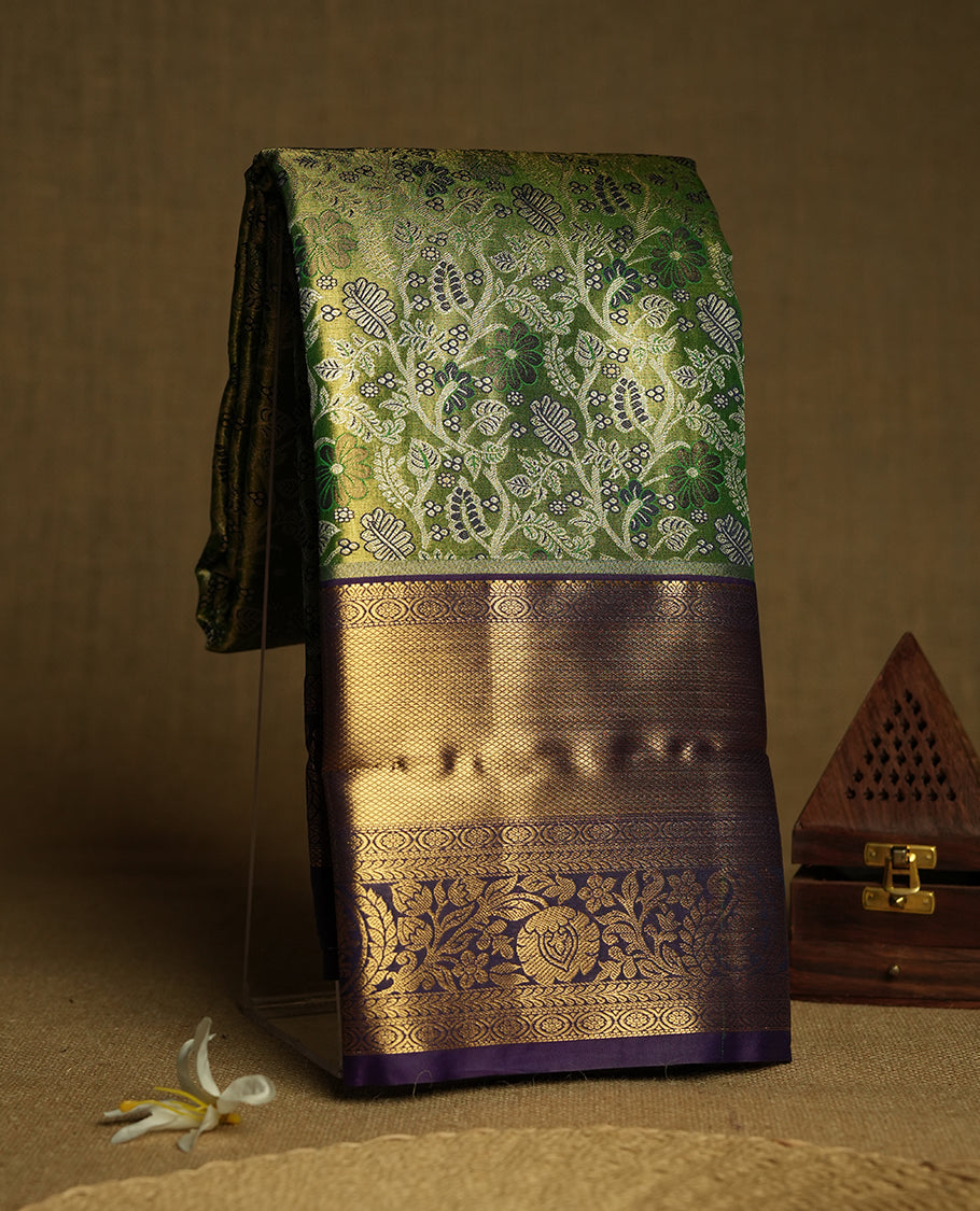 Light green colour and Antique silver Zari Tissue Brocade Saree features intricate floral Motifs on body and navy blue colour traditional border & pallu with floral patterns, paired with matching blouse