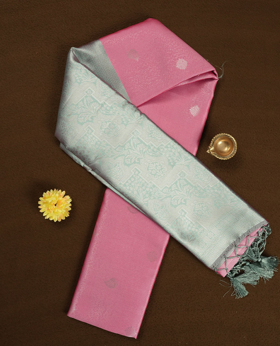 Light pink colour semi silk saree adorned with silver zari designs on the body, complemented by a contrasting light green and silver border and pallu, and paired with a matching blouse piece